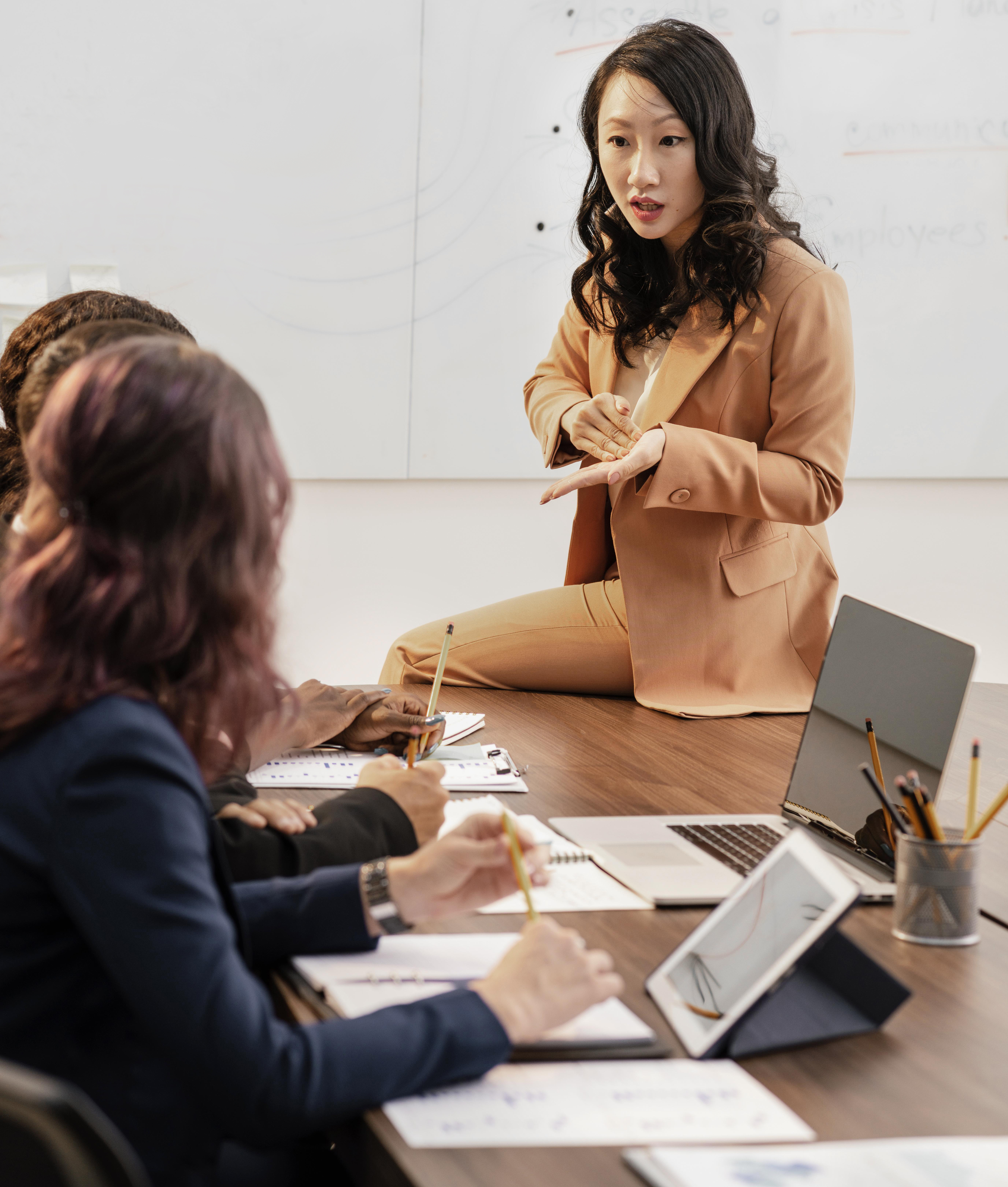 Woman in HR position sitting on a table and explaining assessment process
